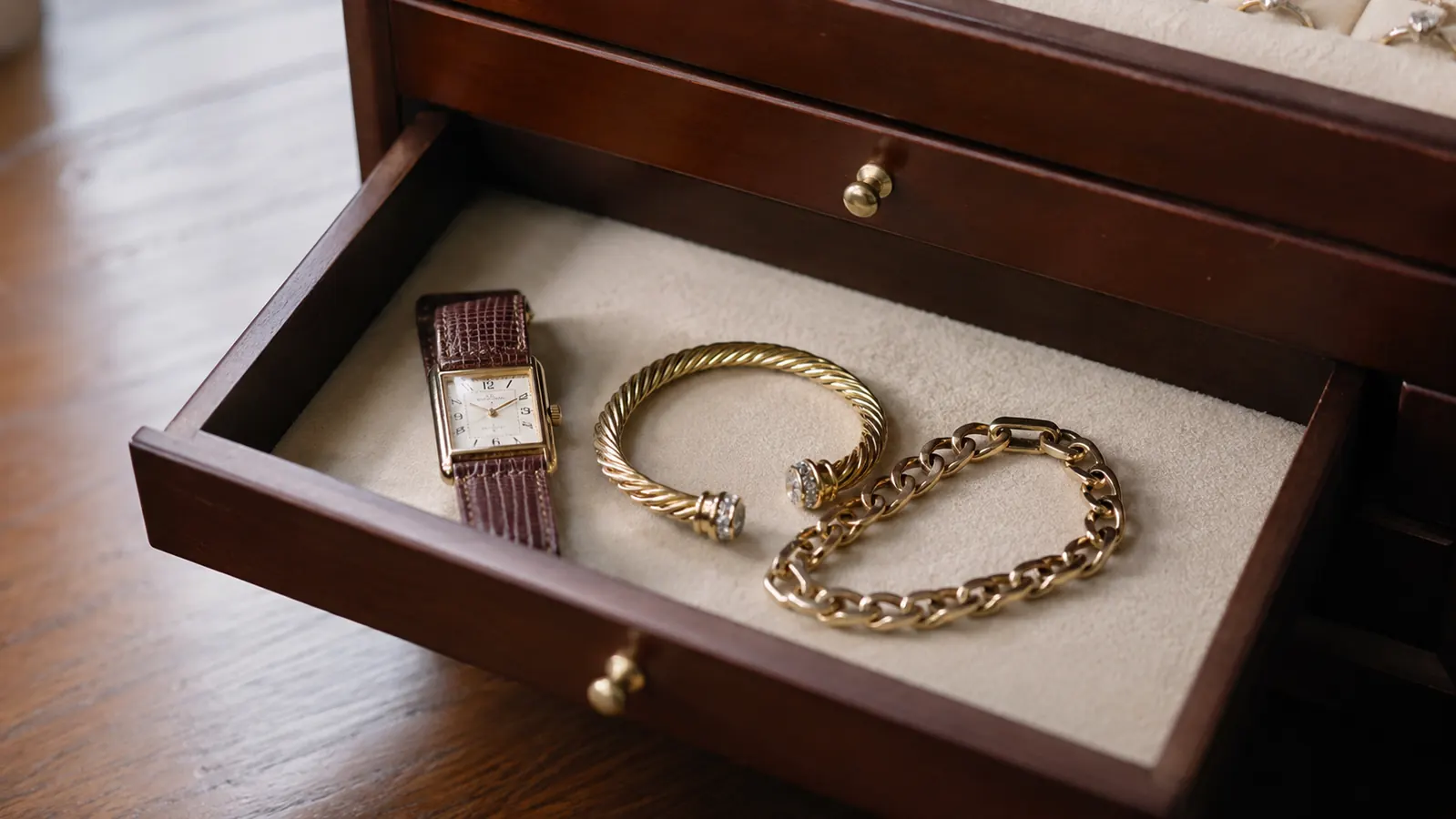 Open bottom drawer of the jewelry box showing bracelets and a watch stored inside